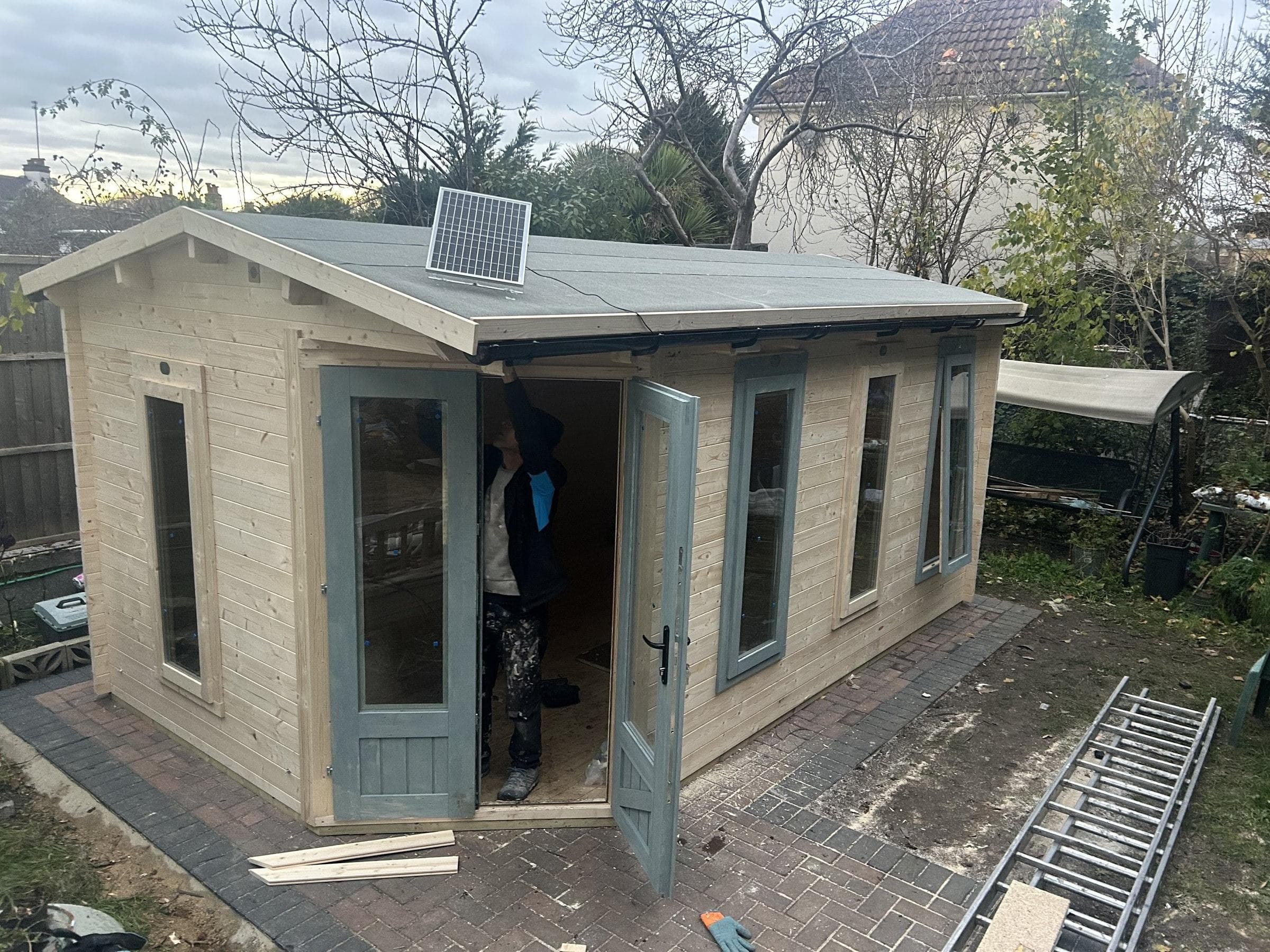 Completed timber garden summerhouse with windows and double doors fitted