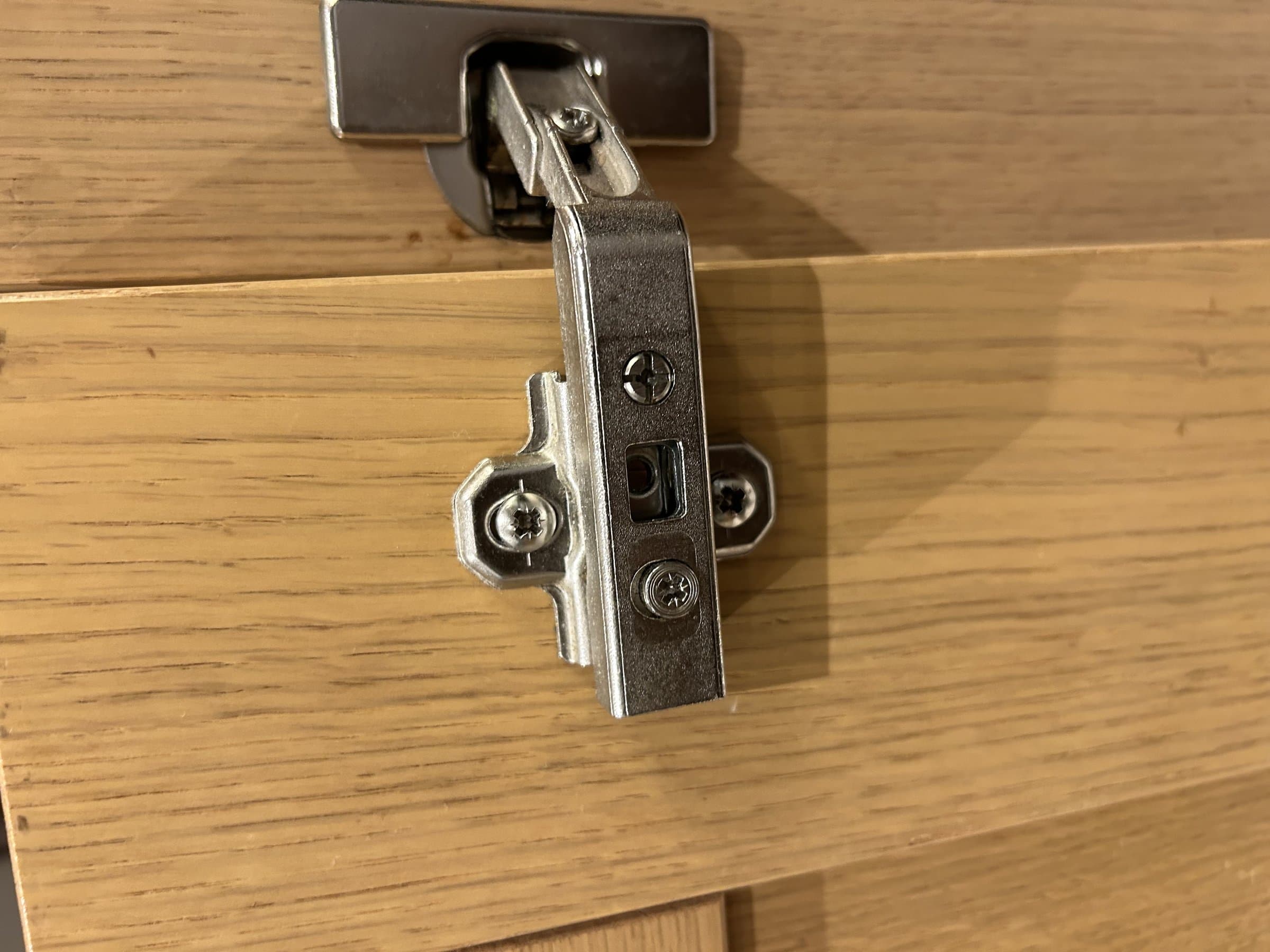 Cabinet door hinge properly reassembled and adjusted