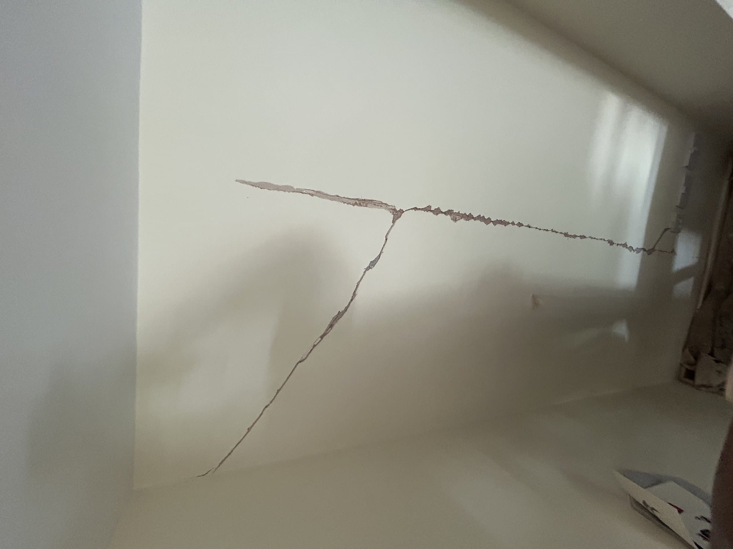 Diagonal wall crack running from a window corner down the wall before repair