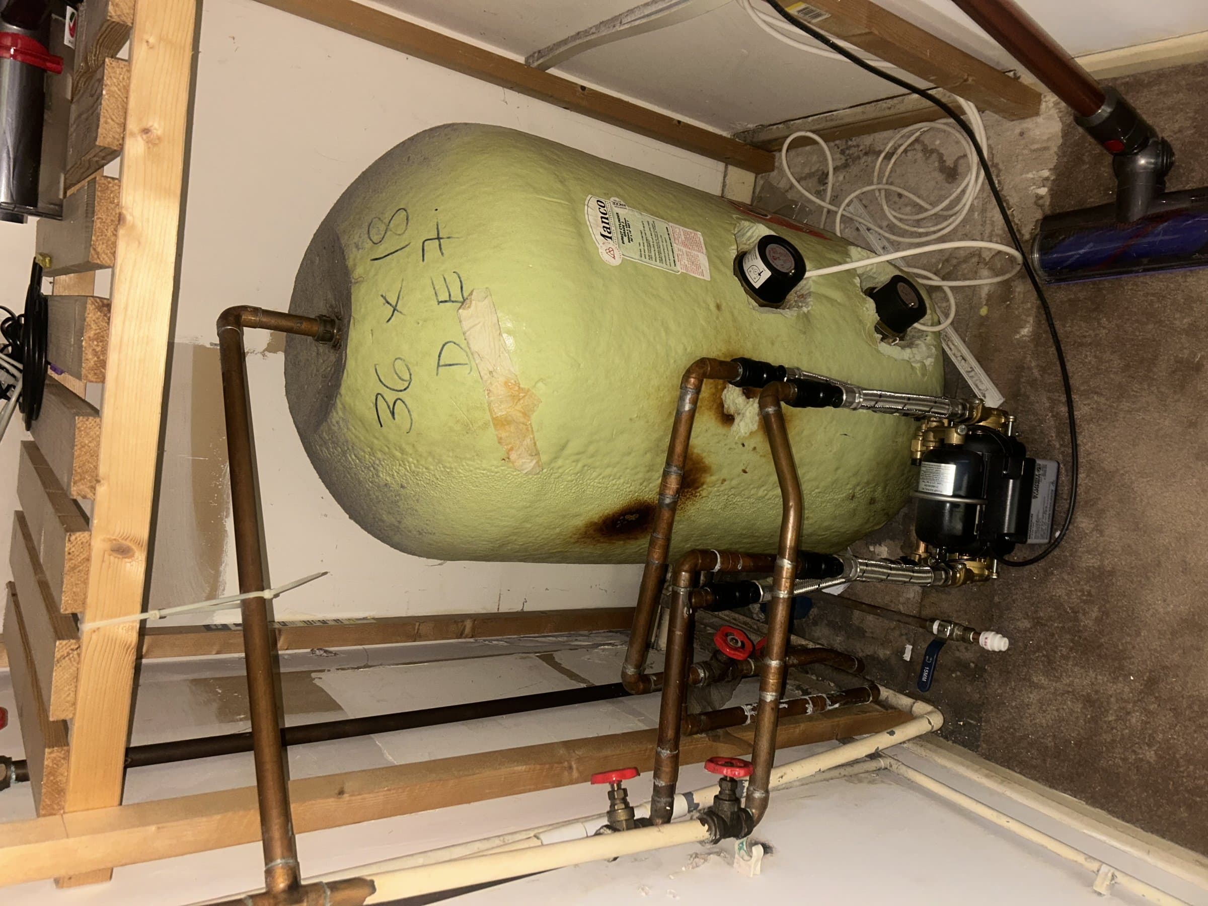 Shower pump and hot water cylinder connected with copper pipework in an airing cupboard