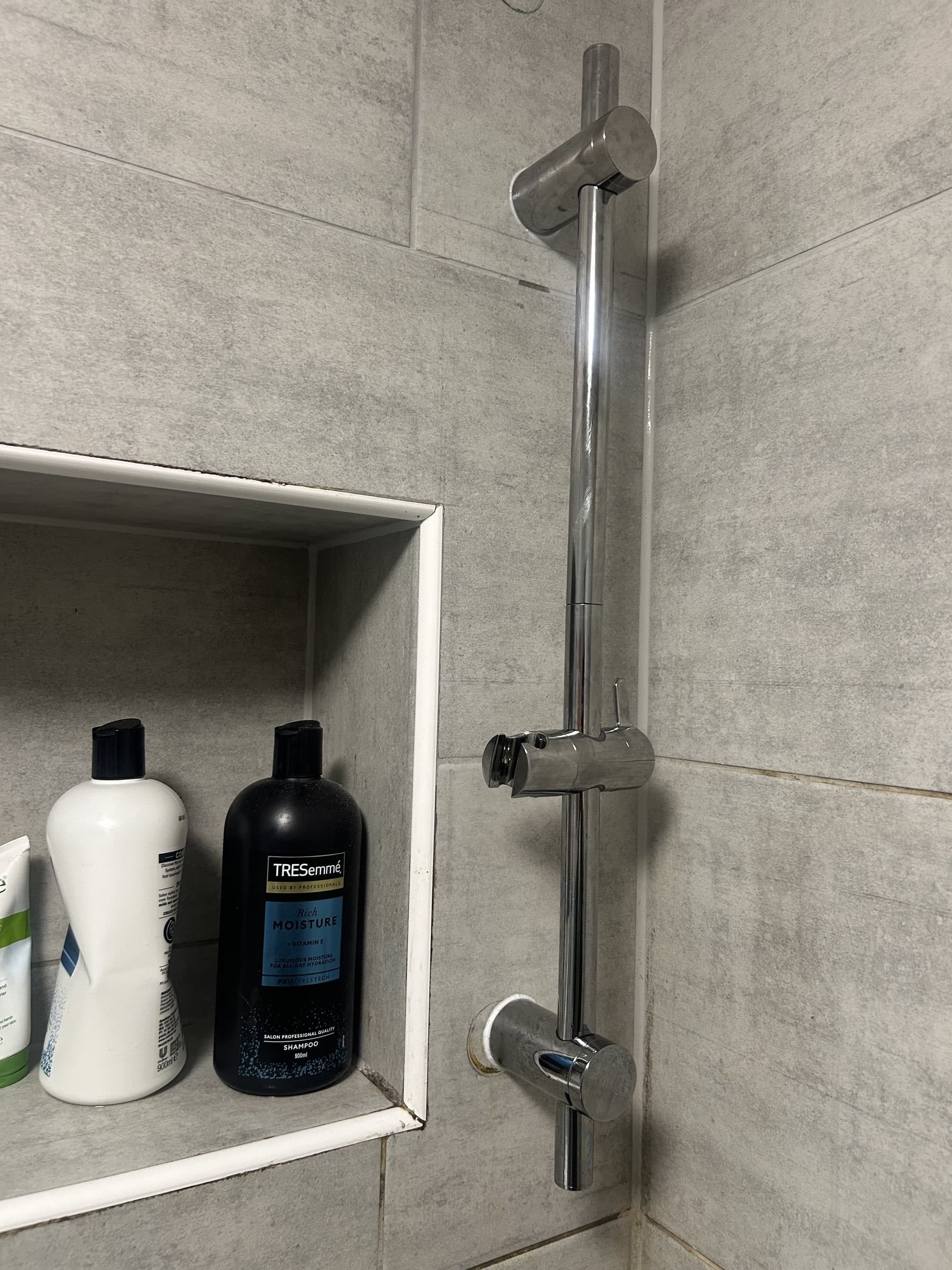 New chrome shower slide rail and shower head fitted in the tiled shower alcove